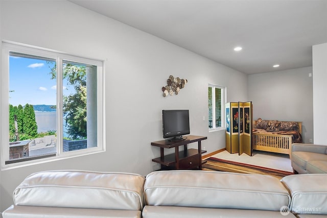 living area with recessed lighting, plenty of natural light, and a water view