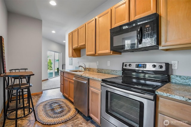 kitchen featuring appliances with stainless steel finishes, light stone countertops, a sink, baseboards, and recessed lighting