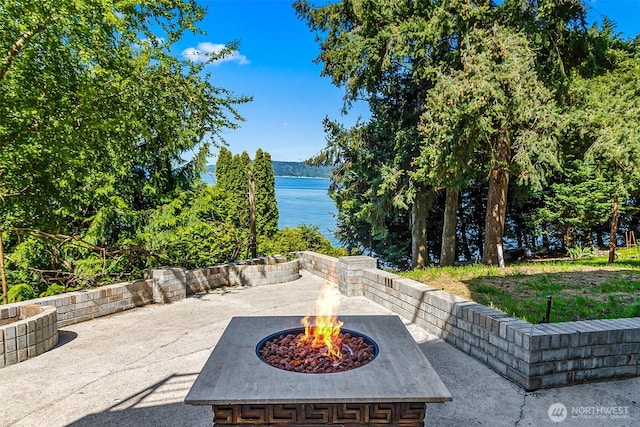 view of patio featuring a water view and an outdoor fire pit