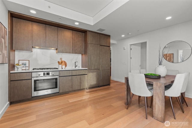 121 Stewart St Unit 2807, Seattle, WA 98101 - kitchen with oven, recessed lighting, light wood-style floors, light countertops, and gas stovetop