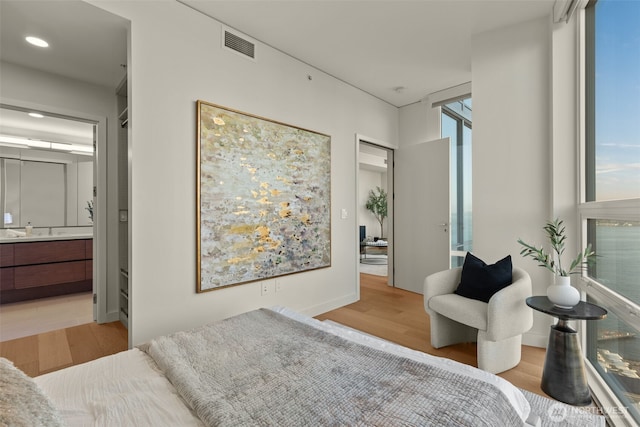 121 Stewart St Unit 2807, Seattle, WA 98101 - bedroom with wood finished floors, recessed lighting, and ensuite bath