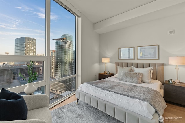 121 Stewart St Unit 2807, Seattle, WA 98101 - bedroom with floor to ceiling windows, wood finished floors, and a view of city