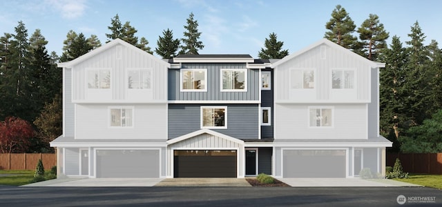 view of front facade with a garage, board and batten siding, and fence