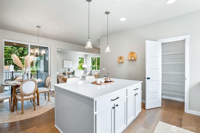 kitchen featuring an inviting chandelier, light countertops, white cabinetry, and dark wood-style floors