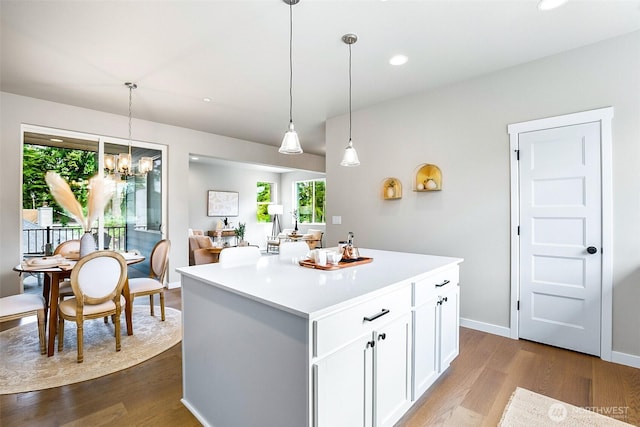kitchen with plenty of natural light, dark wood finished floors, a kitchen island, and white cabinets