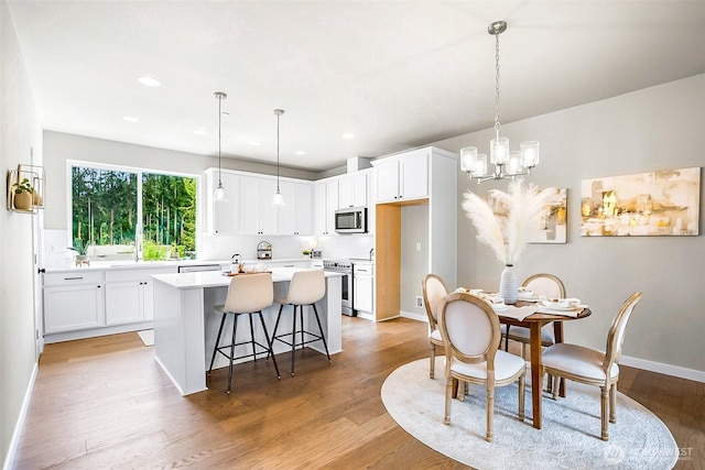 dining room featuring light wood-style floors, baseboards, recessed lighting, and a chandelier
