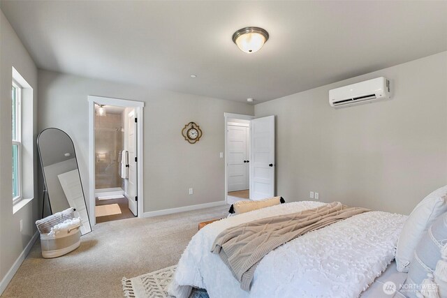 carpeted bedroom with baseboards, ensuite bathroom, and an AC wall unit