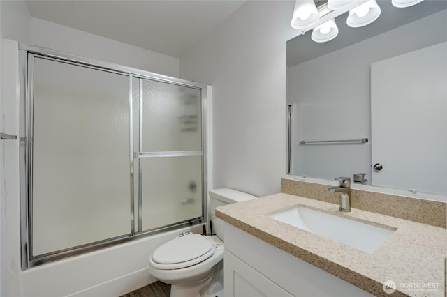full bath with toilet, vanity, and combined bath / shower with glass door