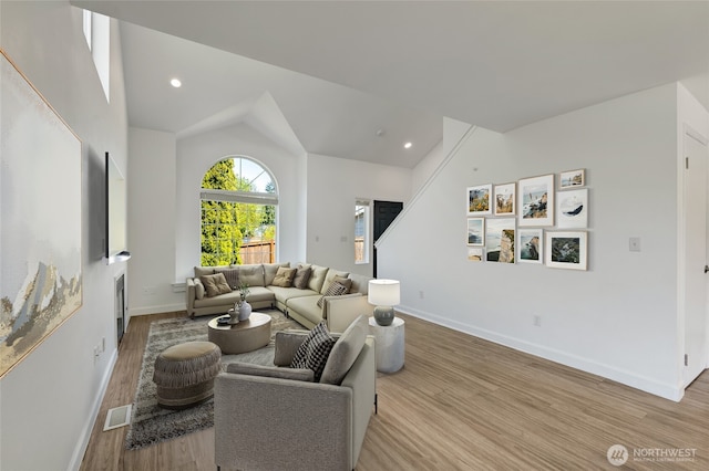 living room with light wood-style floors, vaulted ceiling, baseboards, recessed lighting, and a fireplace