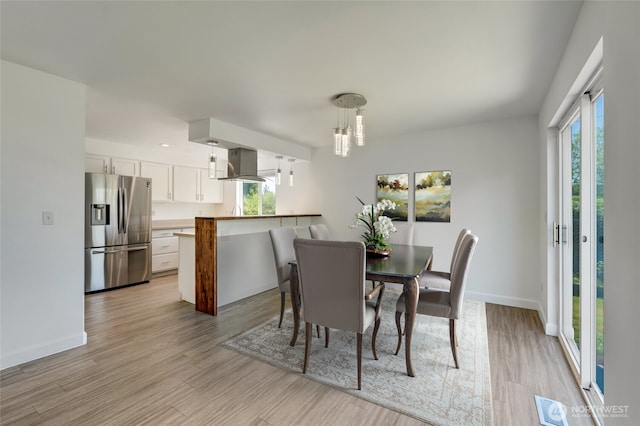 dining area with light wood-style flooring and baseboards