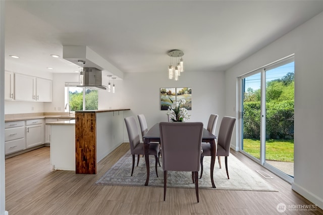 dining area with light wood-style floors, baseboards, and recessed lighting