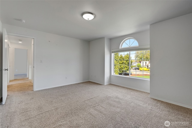 unfurnished room featuring carpet flooring, a smoke detector, and baseboards