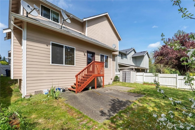 view of front of home featuring a front yard, an outdoor structure, a storage shed, and fence