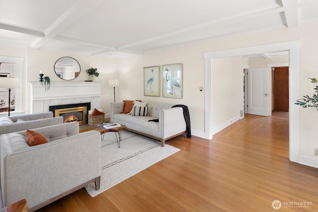 living area with a fireplace, beam ceiling, light wood-style flooring, and coffered ceiling