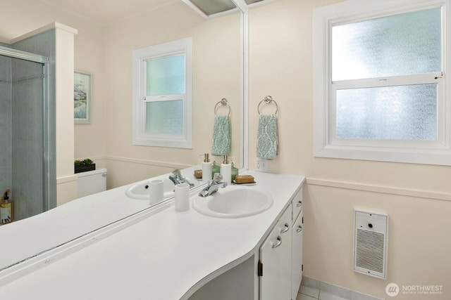 bathroom with a healthy amount of sunlight, vanity, a stall shower, and visible vents