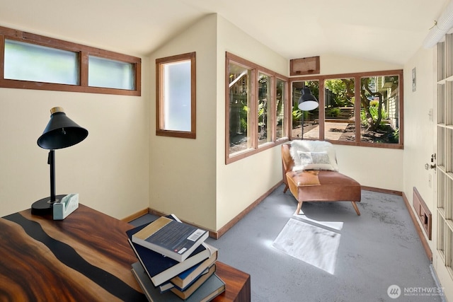 living area with baseboards and lofted ceiling