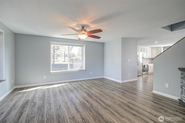 293 Glacier Ct SE, Ocean Shores, WA 98569 - unfurnished living room featuring a ceiling fan, baseboards, and dark wood finished floors