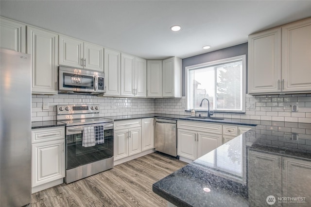 293 Glacier Ct SE, Ocean Shores, WA 98569 - kitchen with decorative backsplash, recessed lighting, a sink, light wood-style flooring, and stainless steel appliances