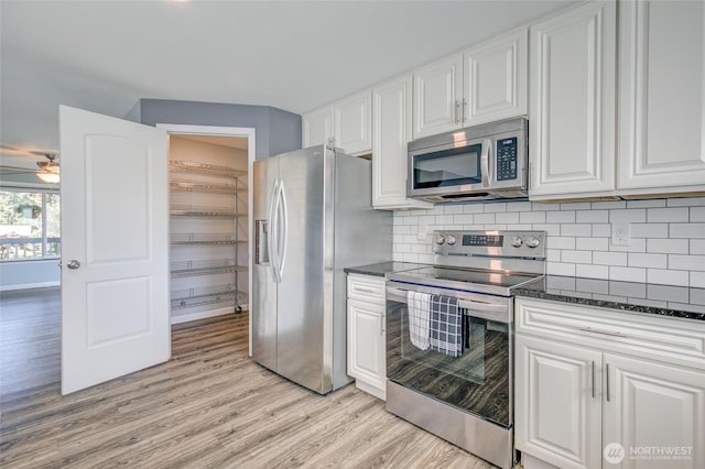 293 Glacier Ct SE, Ocean Shores, WA 98569 - kitchen featuring decorative backsplash, a ceiling fan, light wood finished floors, stainless steel appliances, and white cabinetry
