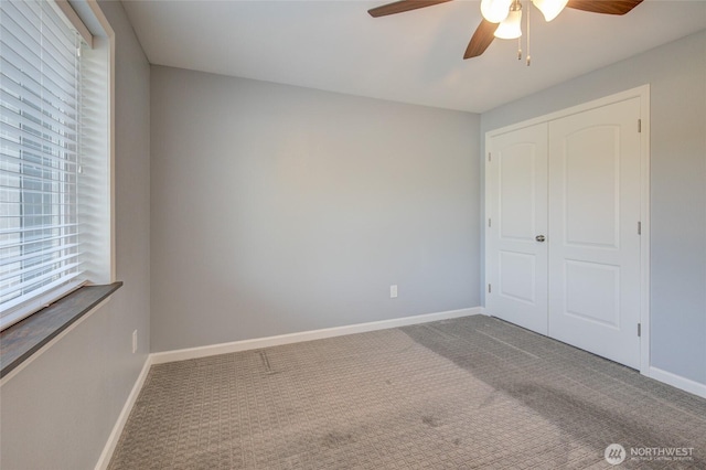 293 Glacier Ct SE, Ocean Shores, WA 98569 - unfurnished bedroom featuring a ceiling fan, baseboards, multiple windows, and carpet