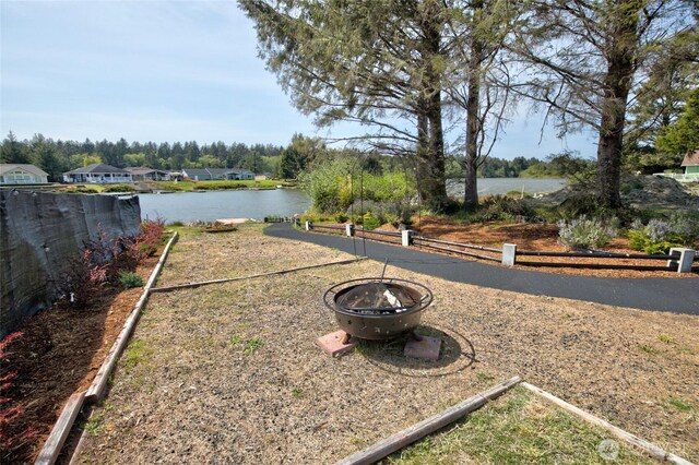 293 Glacier Ct SE, Ocean Shores, WA 98569 - view of yard with fence, a water view, and a fire pit