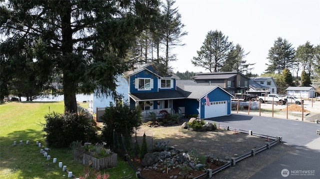 293 Glacier Ct SE, Ocean Shores, WA 98569 - traditional home with fence, an attached garage, a front lawn, a porch, and driveway