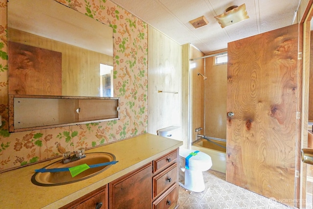 full bath featuring vanity, bathtub / shower combination, wallpapered walls, and toilet
