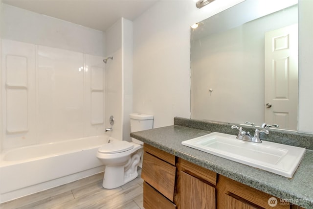 bathroom with toilet, bathtub / shower combination, wood finished floors, and vanity