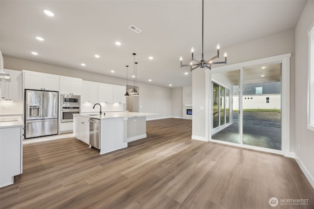10603 134th Ave NE Unit 102, Lake Stevens, WA 98258 - kitchen with white cabinets, appliances with stainless steel finishes, light countertops, open floor plan, and visible vents