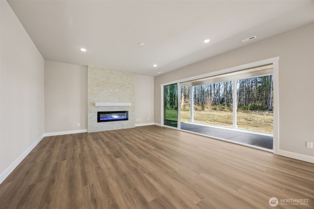10603 134th Ave NE Unit 102, Lake Stevens, WA 98258 - unfurnished living room featuring baseboards, a stone fireplace, and wood finished floors