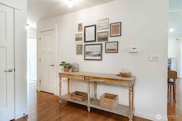 hallway with baseboards and wood finished floors