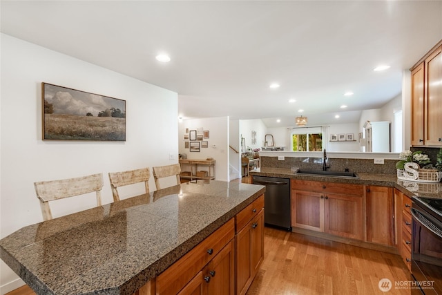 kitchen with stainless steel dishwasher, tile counters, black electric range, a sink, and light wood-style flooring
