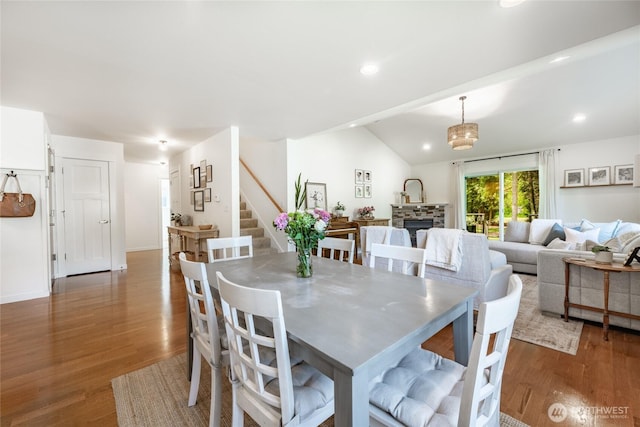 dining room featuring stairway, recessed lighting, wood finished floors, and lofted ceiling