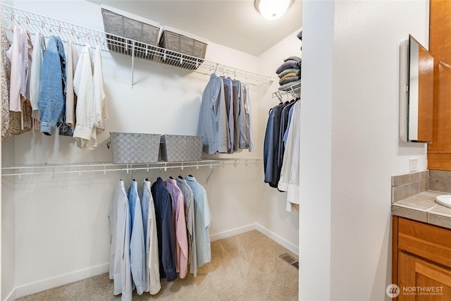 spacious closet featuring visible vents and light carpet