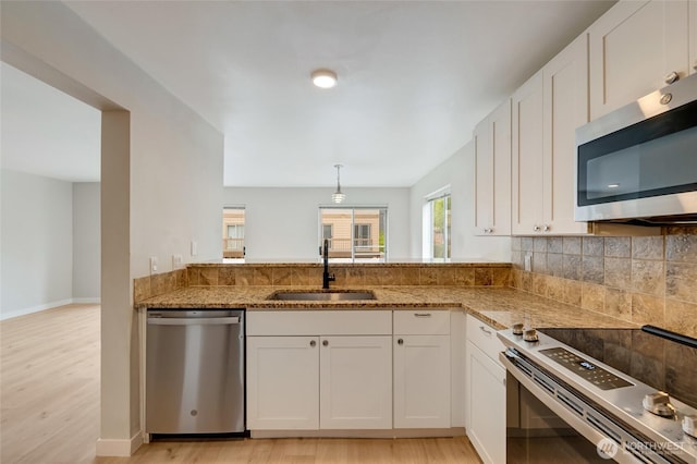 16820 6th Ave W Unit A4, Lynnwood, WA 98037 - kitchen featuring stainless steel appliances, a sink, light stone counters, and light wood-style flooring