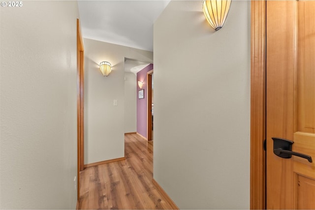 hall featuring baseboards and light wood-style floors