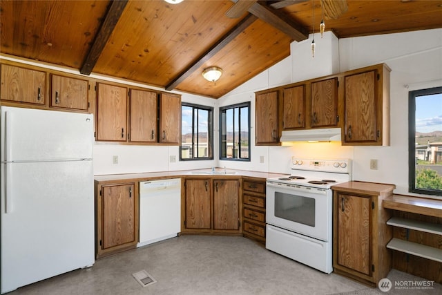kitchen with brown cabinetry, a sink, vaulted ceiling with beams, under cabinet range hood, and white appliances
