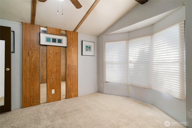 unfurnished bedroom featuring carpet flooring, a ceiling fan, and vaulted ceiling