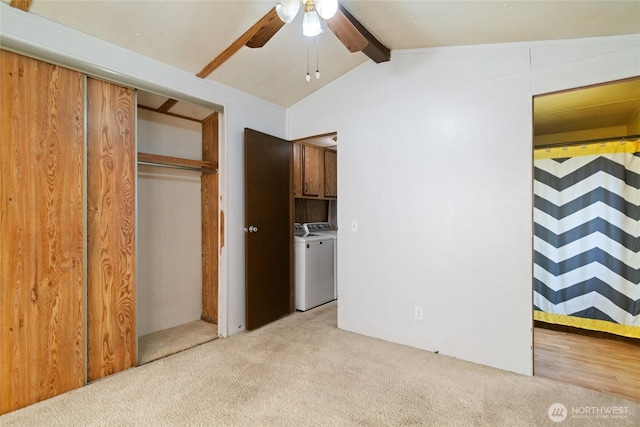 unfurnished bedroom featuring carpet floors, a closet, ceiling fan, vaulted ceiling with beams, and separate washer and dryer