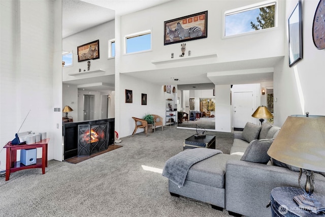 living room with a fireplace with flush hearth, a high ceiling, and carpet