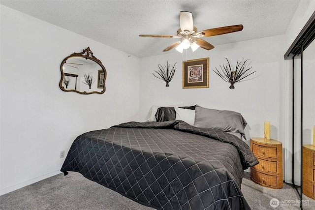 carpeted bedroom featuring baseboards, a ceiling fan, and a textured ceiling