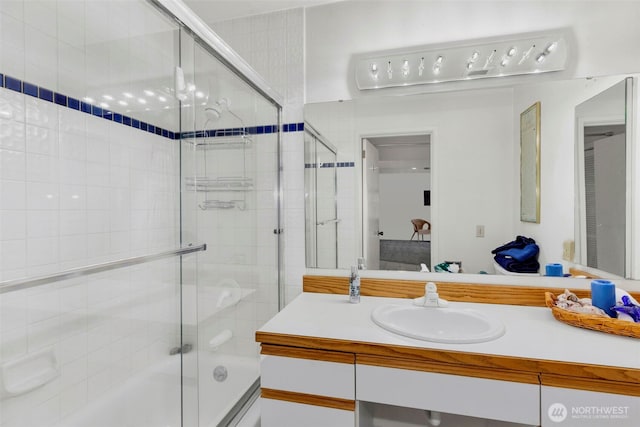 bathroom featuring shower / bath combination with glass door and vanity