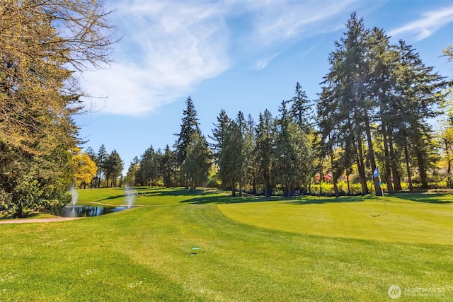 surrounding community with a lawn, a water view, and golf course view