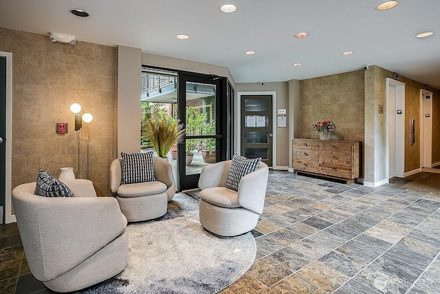 interior space featuring stone tile floors, recessed lighting, baseboards, and elevator