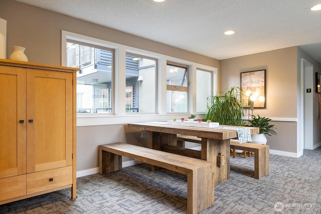 carpeted dining room with recessed lighting, a textured ceiling, baseboards, and a healthy amount of sunlight