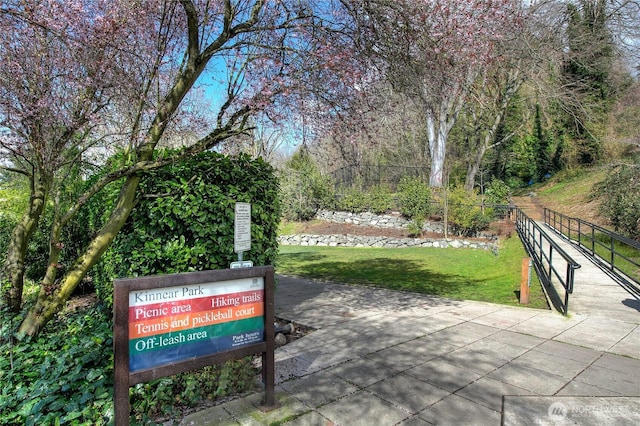 view of home's community with a lawn and fence
