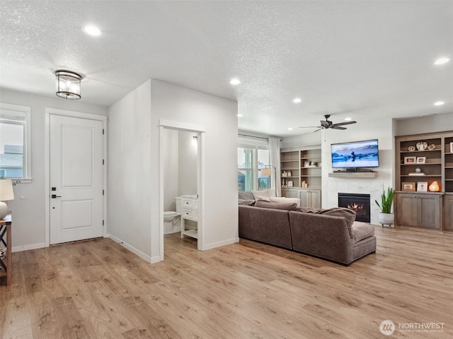 904 E Tanoak Ave, La Center, WA 98629 - living room featuring a textured ceiling, ceiling fan, a lit fireplace, recessed lighting, and light wood finished floors