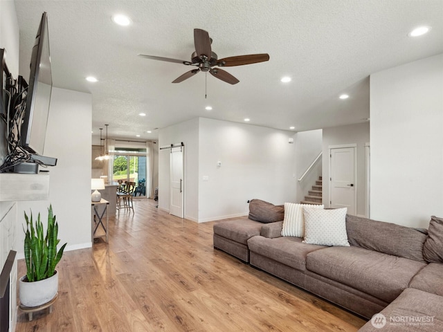 904 E Tanoak Ave, La Center, WA 98629 - living room with a barn door, recessed lighting, a ceiling fan, light wood-type flooring, and stairway