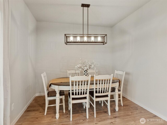 904 E Tanoak Ave, La Center, WA 98629 - dining space featuring wood finished floors, baseboards, and a chandelier