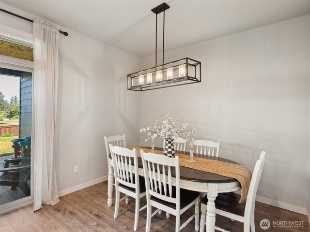 904 E Tanoak Ave, La Center, WA 98629 - dining room featuring baseboards, light wood finished floors, and a chandelier